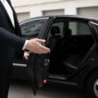 autista accoglie cliente su macchina noleggio con conducente