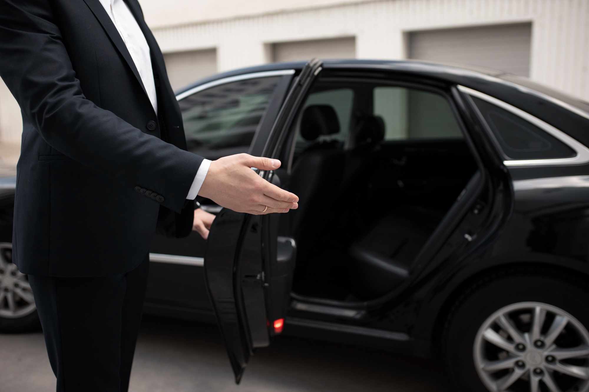 autista accoglie cliente su macchina noleggio con conducente